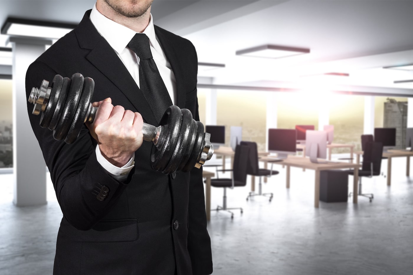 Businessman in modern office wheightlifting power
