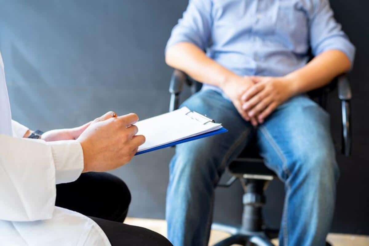 Man speaks to dr with clipboard