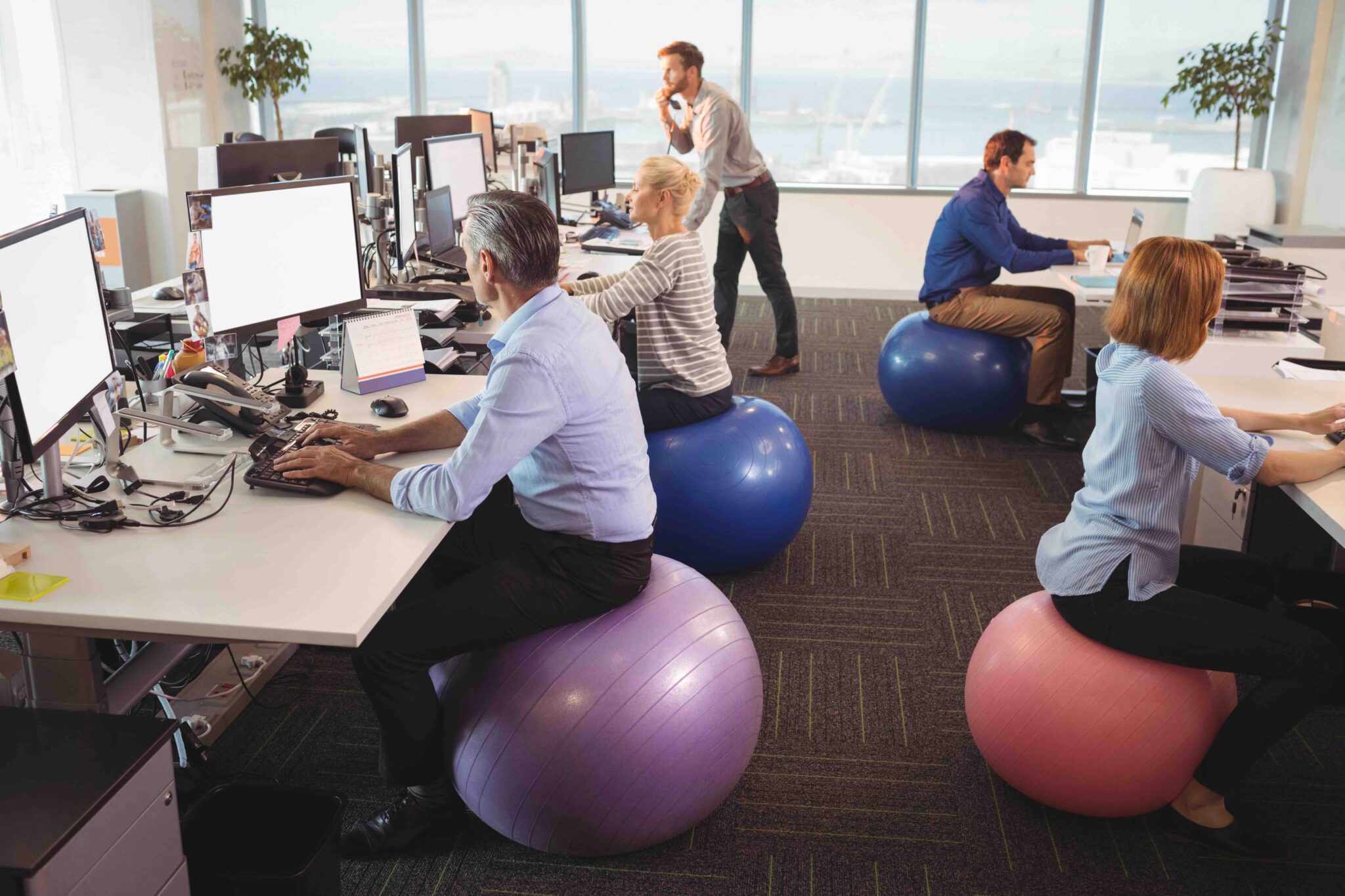 Office workers sitting on gym ball