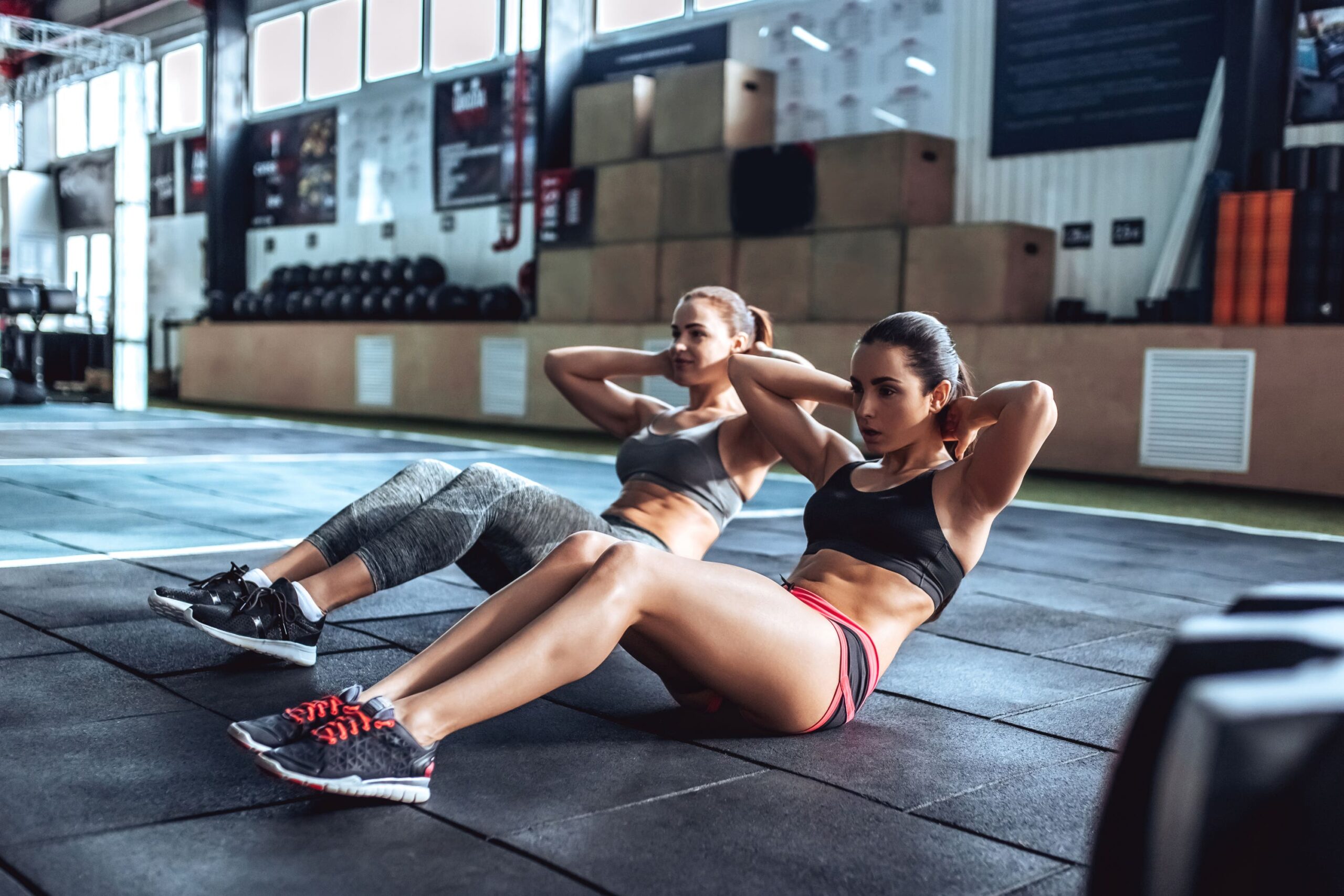 Women perform crunches scaled