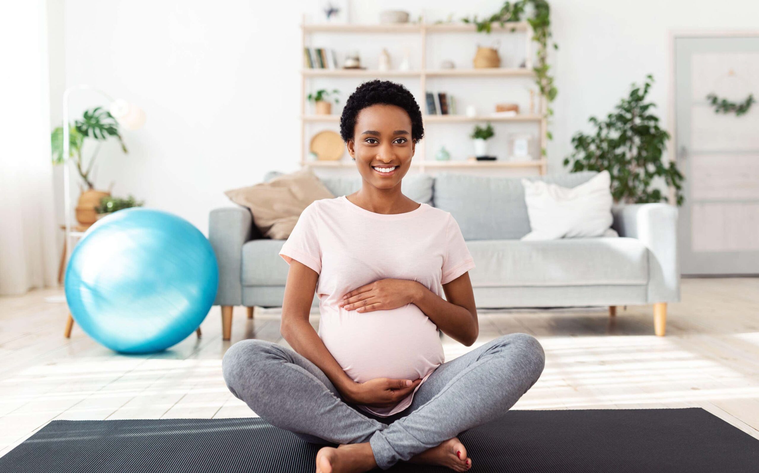 Pregnant woman sits feeling stomach scaled