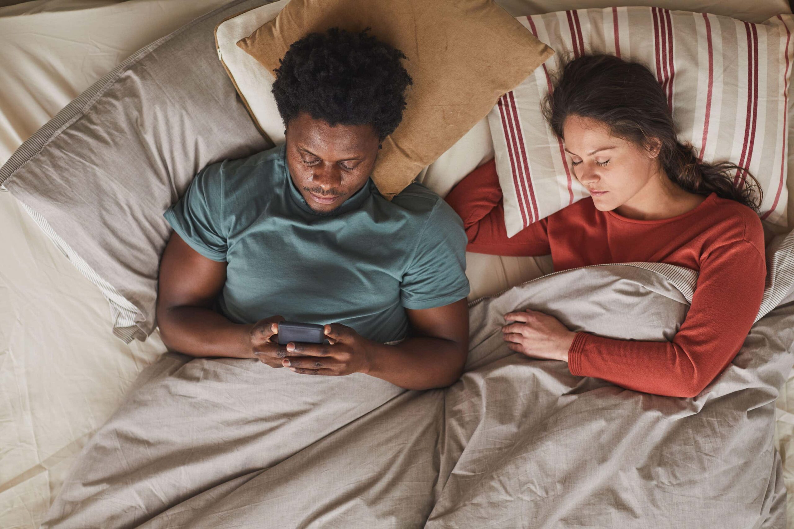 couple laying in bed not sleeping scaled