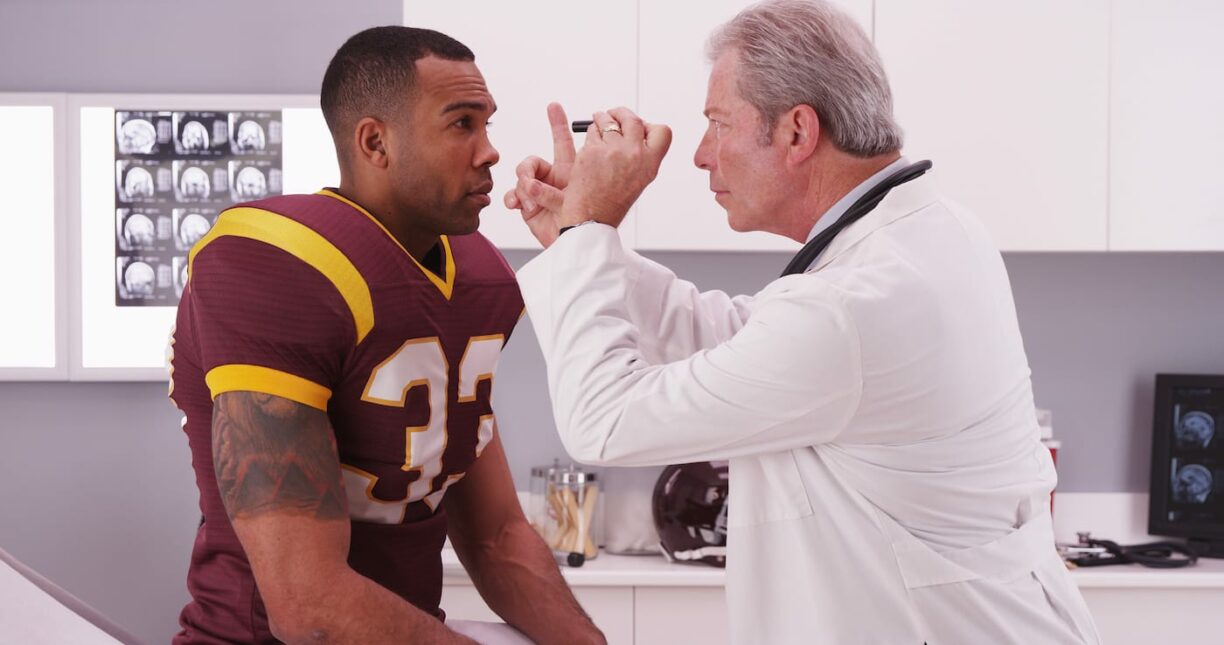 football player having senior doctor review his concussion
