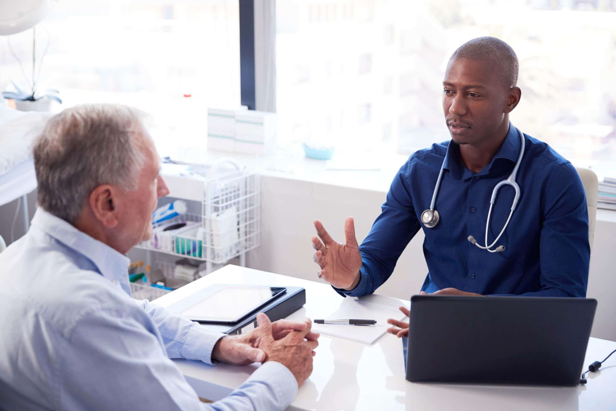 Man sits talking with his doctor scaled