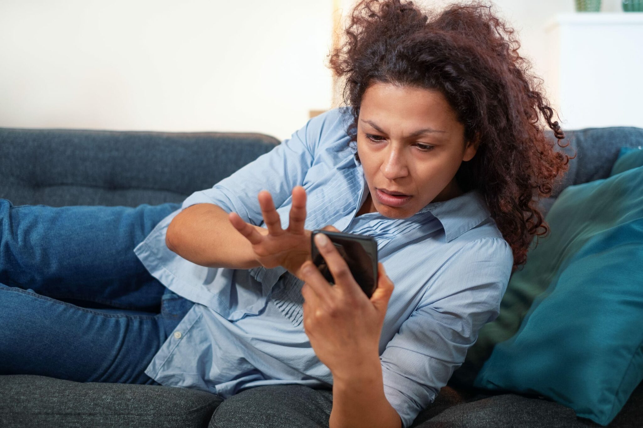 woman looks stressed looking at television remote