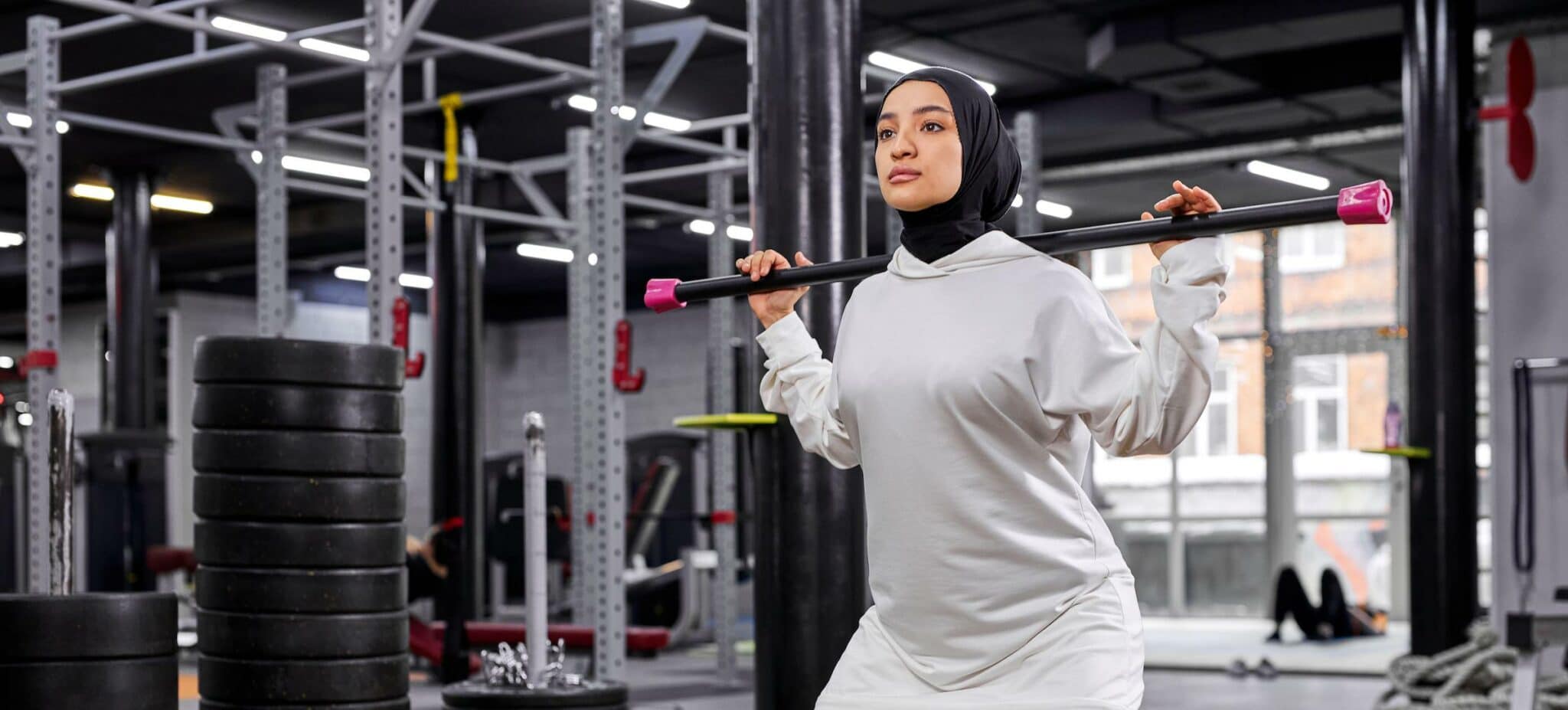muslim woman lifts heavy weights in gym e1648664208211