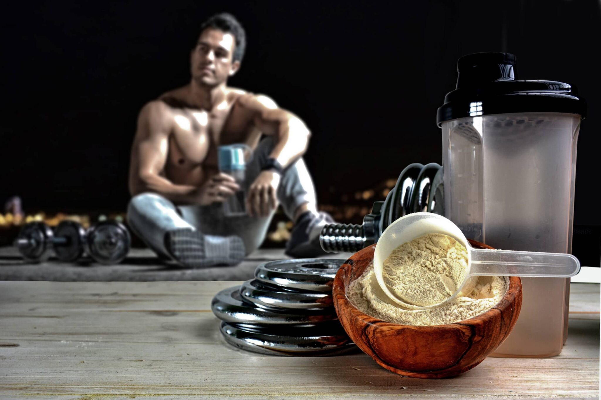 Fit man sits looking at protein powder drink