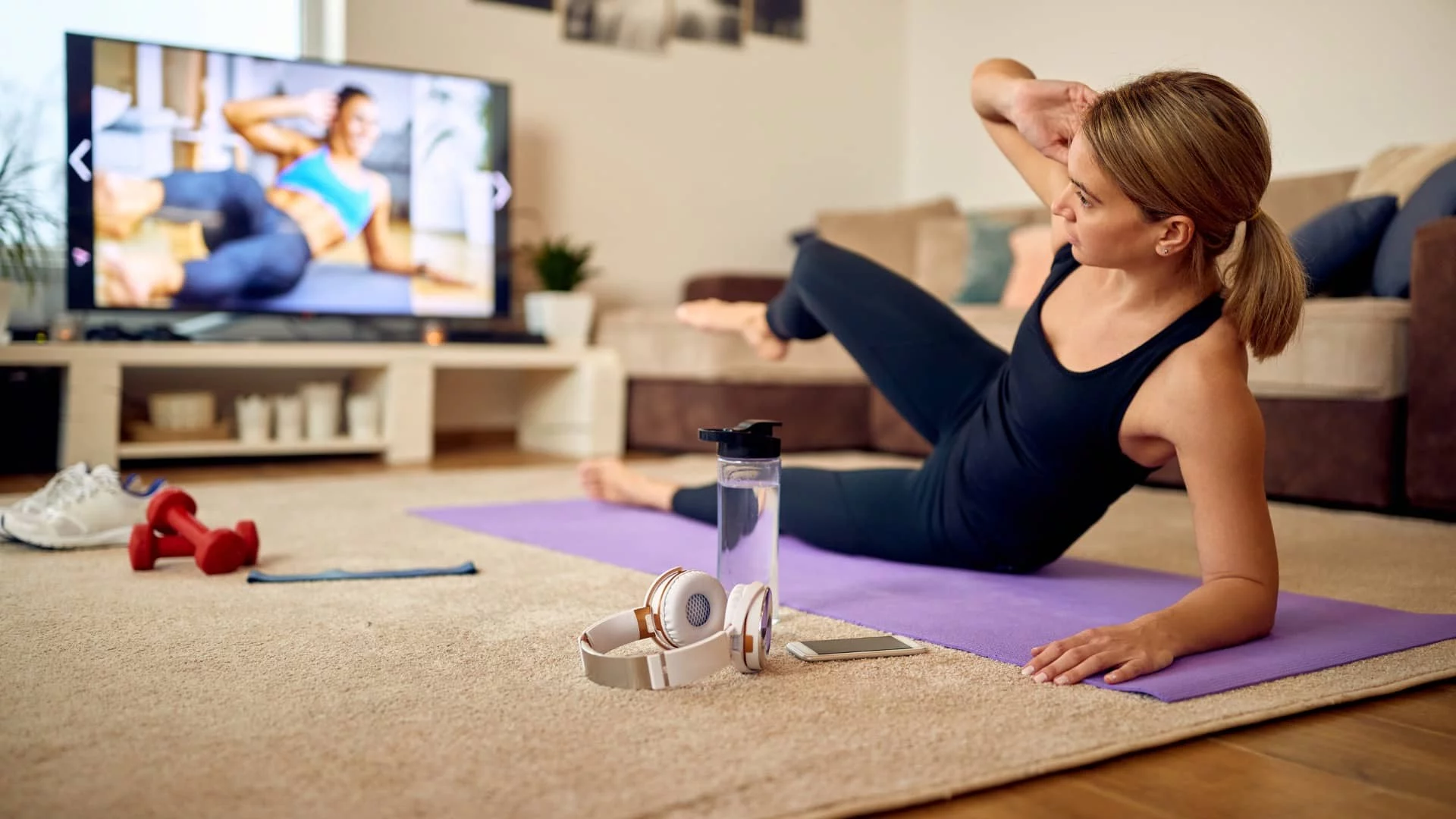 woman works out in front of television