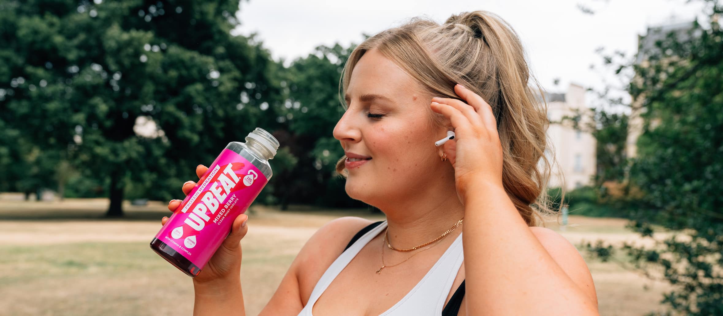 Fitness woman drinks from upbeat bottle